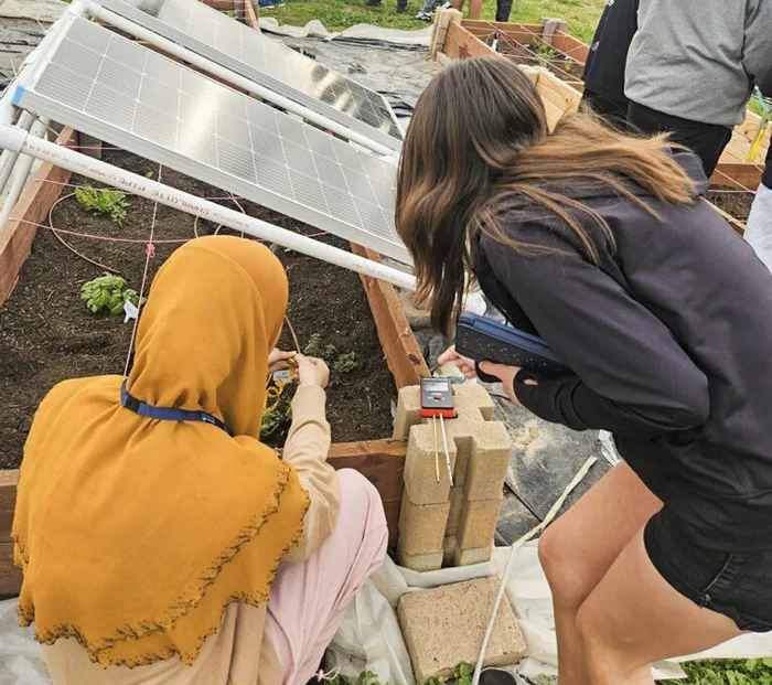Students tending an experiment in an Agrivoltaic garden